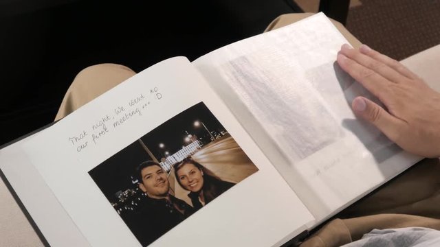Man alone watching leafing through the Photo Album of romantic Honeymoon