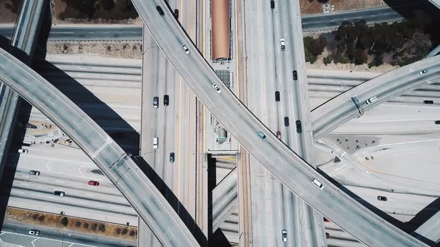 Incredible aerial shot of a big freeway intersection in Los Angeles, USA, traffic going fast through many road flyovers.