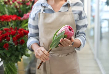 Cercles muraux Fleuriste Fleuriste femme tenant une belle fleur en boutique