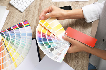 Woman with color palette samples at table, closeup