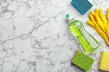 Flat lay composition with cleaning supplies for dish washing and space for text on marble background