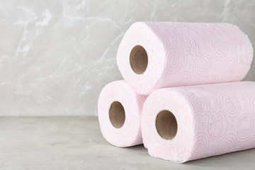 Rolls of toilet paper on grey table. Space for text