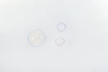 Beautiful translucent soap bubbles on light background. Space for text