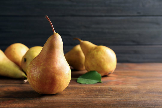 Ripe pear on wooden table. Space for text