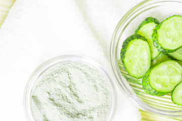 Cucumber home spa and hair care concept. Sliced cucumber, bottles of oil, sea salt, bathroom towel. Straw light background