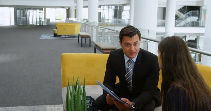 Business people discussing over document on sofa 4k