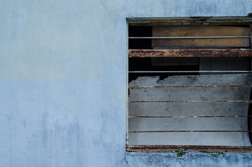 Half a window of a blue house. sidewalk.