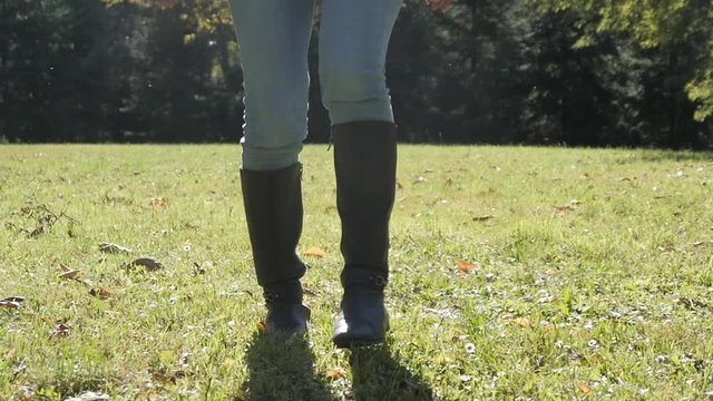 Close-up Legs - Woman dancing in a Park - Blue Jeans and high Boots 