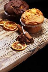 Chocolate muffin and nut muffin, homemade bakery on wooden background.