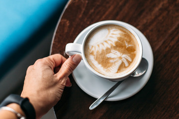 Cup of hot latte art coffee on wooden table