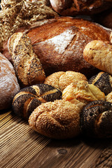 Different kinds of bread and bread rolls on board from above. Kitchen or bakery