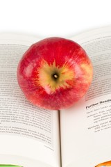 Apple sitting in the binding crease of an open book