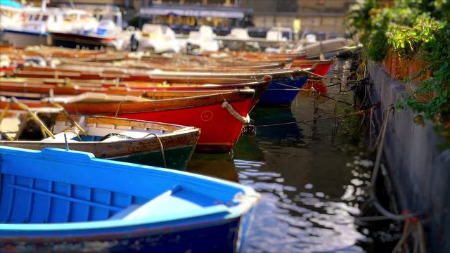 Colorful wooden rowboats moored in marina, Naples, Italy