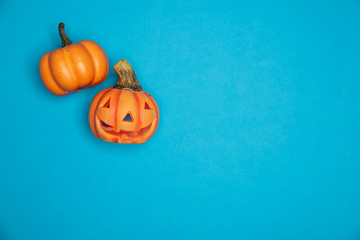 Halloween sculpted pumpkin funny and cute faces. Flat lay against blue background. October symbol
