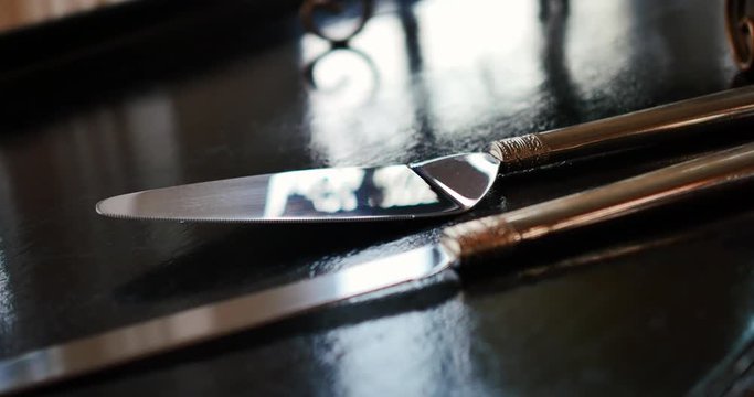 Polished cake knife on black reflective wedding table