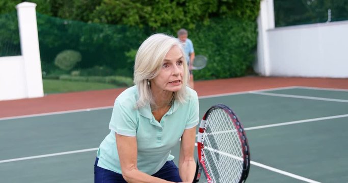 Senior woman playing tennis in tennis court 4k