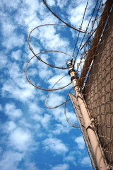Barbed wire fence with cloudy sky