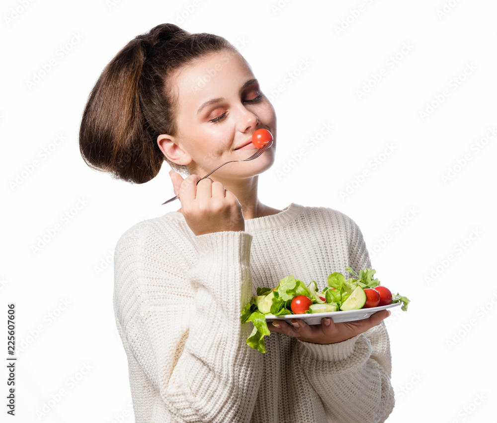 Wall mural portrait of attractive young caucasian smiling woman isolated on white studio shot eating salat