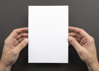 Obraz premium Mens hands holding white letterhead