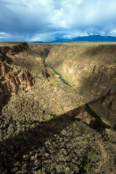 The bridge over the Rio Grande Gorge casts a long shadow across its 800' deep canyon, which lies on the Taos Plateau in New Mexico; looking north from US Hwy 64