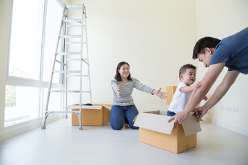 Fototapeta na wymiar Happy Asian family with cardboard boxes in new house at moving day, Real estate and home concept