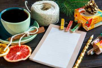 notepad lays on the wooden background to make a list to do things or list of presents for friends and family. New year and Christmas concept