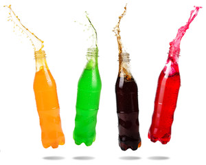 Orange juice, Green soda, Cola and Red soda splashing out of bottle isolated on white background.