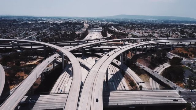 Static drone aerial shot of large complex highway road junction with cars moving through multiple flyovers and bridges.