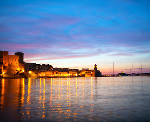 Beautiful small bay with old church of Our Lady of the Angels in the Collioure at late evening
