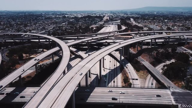 Drone flying around Judge Pregerson highway junction in Los Angeles, cars going over complex flyovers and intersections.