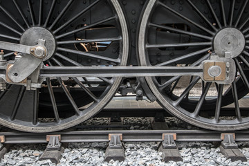 Detail of steam locomotive wheel on tracks.
