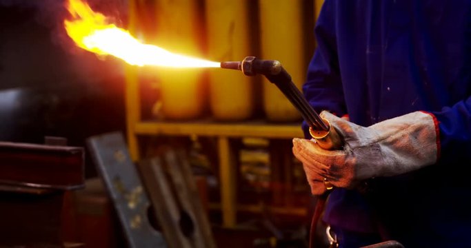 Male engineer using velding torch in workshop 4k
