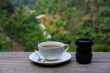 A cup of coffee on the table with the view in the front.