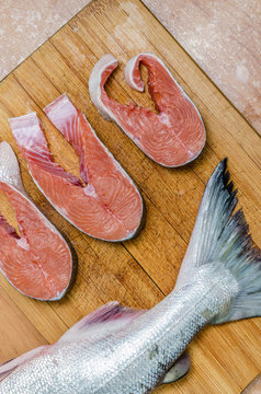 salmon raw on a chopping Board and cut pieces