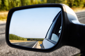 View of the road through the rear view mirror in the car