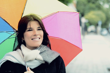 Beautiful woman under rainbow umbrella
