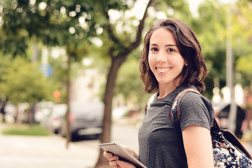 Portrait of beautiful young woman using tablet outdoors