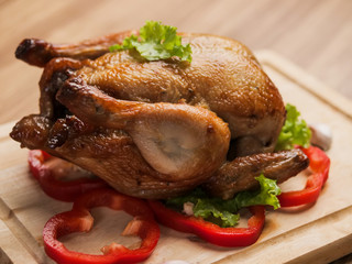 Roasted chicken on wooden board, food concept.