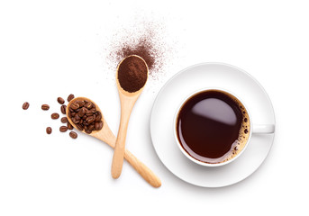 Coffee beans and ground coffee on wooden spoon with cup of black coffee