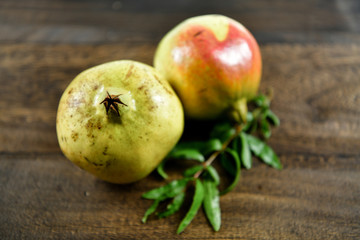Pomegranate fruit with leaf on wood background