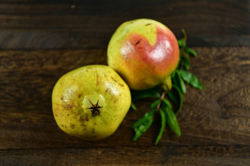 Pomegranate fruit with leaf on wood background