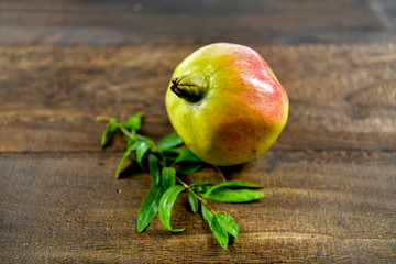 Pomegranate fruit with leaf on wood background