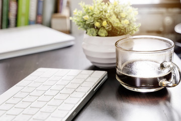 cup of coffee and computer keyboard on wooden table