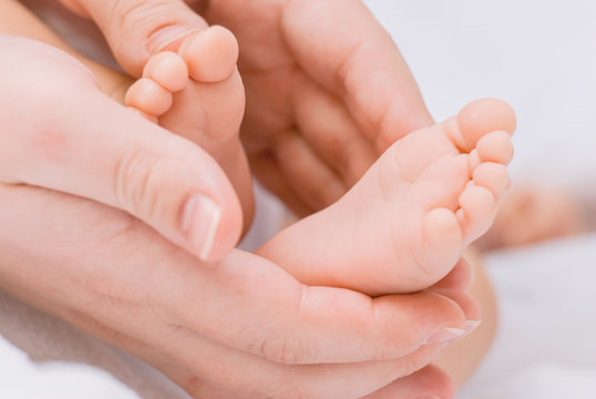 Close-up of mother hands holding tiny baby feet