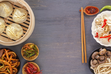 Dishes of Chinese cuisine in assortment. Steam dumplings, noodles, salads, vegetables, mushrooms, seafood. Top view. Copy space