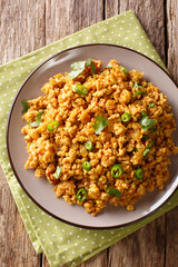 Indian dish Chicken Keema, with onions, tomatoes, spices and minced meat closeup. Vertical top view