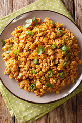 Indian minced chicken Bhuna Keema roasted with spices, tomatoes, chili peppers and onions close-up on a plate. Vertical top view