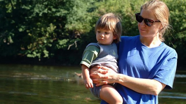 Cinemagraph of a portrait of a mother and baby with a stream flowing in the background.