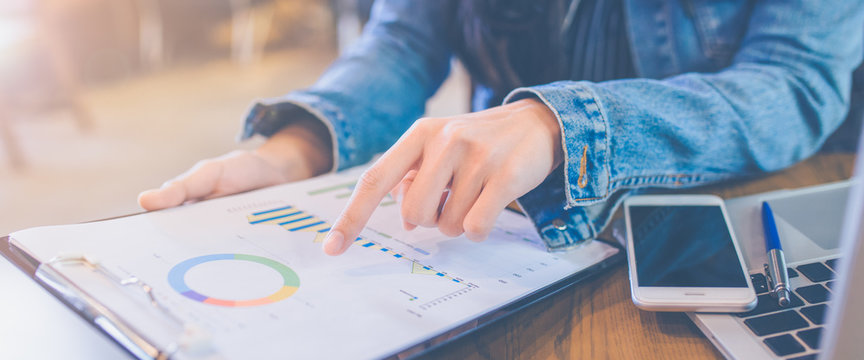 The hands of women using smartphone and laptop computers.She used her index finger to Business Graph Analysis