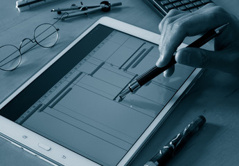 engineer working over timeline gantt progress chart of project on tablet computer screen